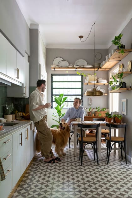 En el comedor diario, mesa y sillas heredadas, mantel (Zara Home), lámpara de techo (Falabella) y estantes hechos a medida por los dueños de casa con vajilla a la vista. Paredes color ‘Telaraña’ (Alba)