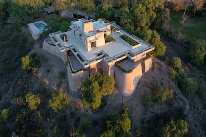 Un poco separada de la casa hay una cochera-quincho y una pileta revestida en travertino.