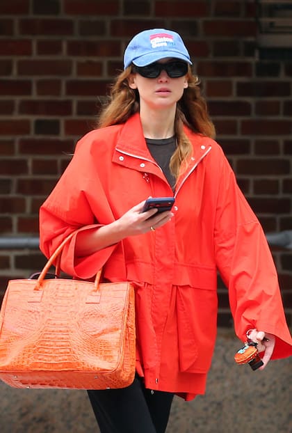 Jennifer Lawrence fue vista en las calles de Nueva York con un estilo muy relajado. La actriz combinó unos pantalones negros con una campera coral de Roucha Janssen y una gorra vintage de la campaña de Bill Clinton–Al Gore en este look urbano