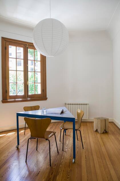 Mesa diseñada por el arquitecto Facundo Fernández (Flora Oficina). Sillas vintage ‘Serie 7’, de Arne Jacobsen; su terminación reitera casi con exactitud el tono del piso y de las aberturas. Taco ‘Álamo’ (La Base Studio).